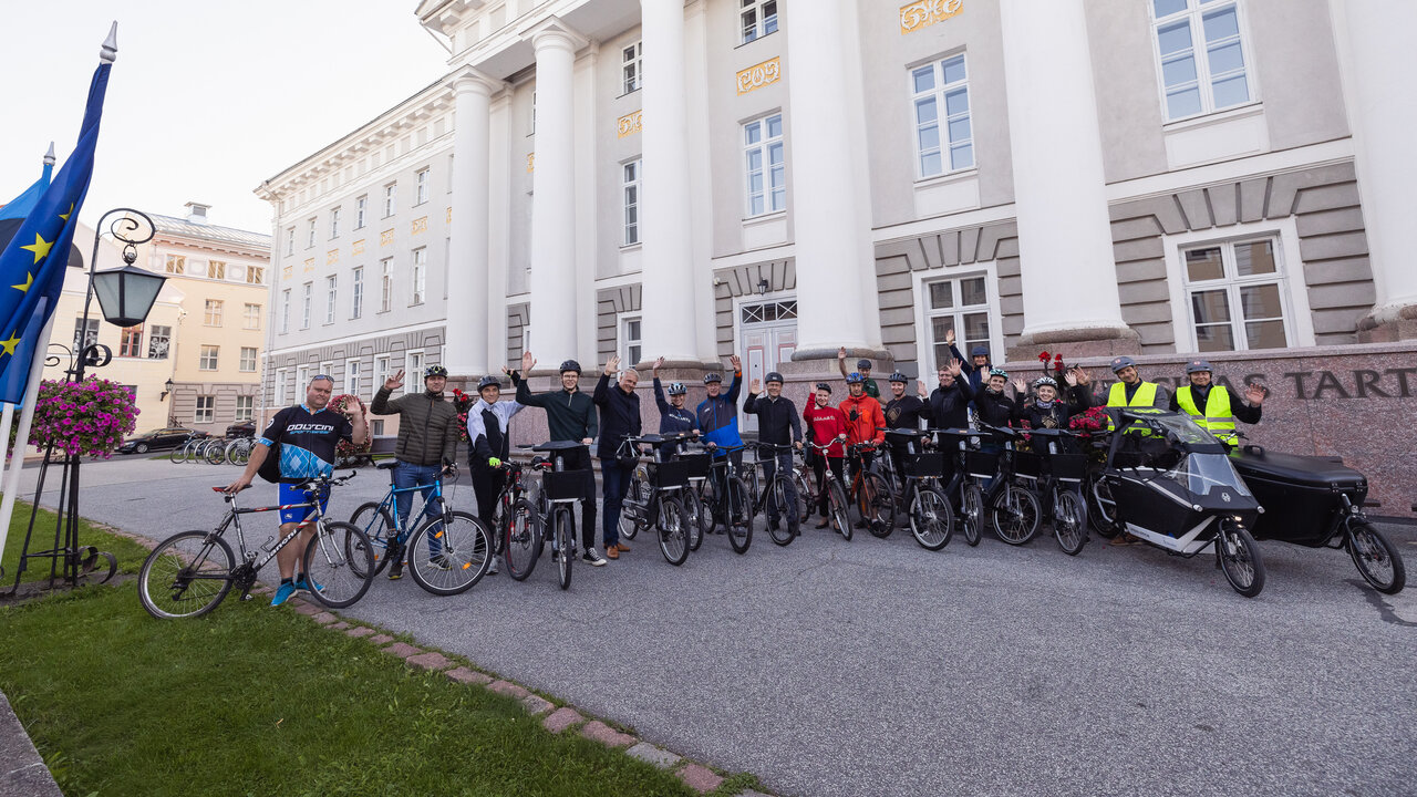 Tartu kõrgkoolide esindajad koos jalgratastega Tartu Ülikooli peahoone ees.