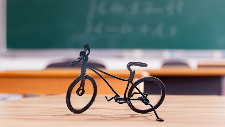 Jalgratas, mis on koolitahvli ja laudade taustal. 